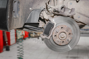 Closeup disc brake of the vehicle for repair in garage.