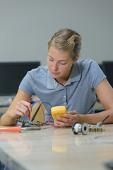 a woman testing electrical parts