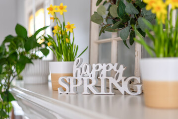 Happy Spring sign on the mantel with yellow daffodils - 491328211