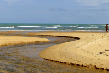 Pequeno rio que se encontra com o mar na praia dos espelhos que é um apelido devido ao efeito causado pelo reflexo do sol nas piscinas naturais quando avistadas do mar no povoado de Caraíva, Bahia.
