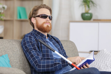 blind man reading book on the sofa