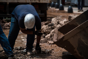 construction worker moving stone debris by hand