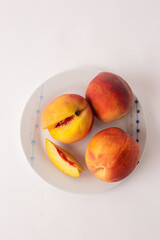ripe peaches on a plate, white background