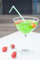 Colorful bright green cocktail cactus with strawberries, delicious refreshing
