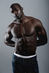 Fototapeta premium Hes solid. A handsome and muscular young man posing in the studio.