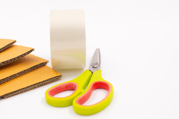 Cardboard box with scotch tape and scissors on a white background, Online sales ideas.