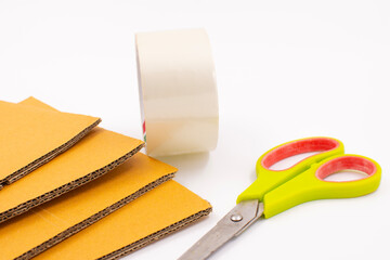 Cardboard box with scotch tape and scissors on a white background, Online sales ideas.
