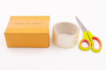 Cardboard box with scotch tape and scissors on a white background, Online sales ideas.