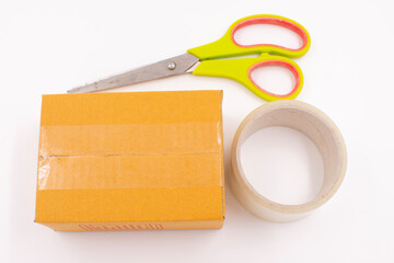 Cardboard box with scotch tape and scissors on a white background, Online sales ideas.
