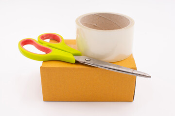 Cardboard box with scotch tape and scissors on a white background, Online sales ideas.