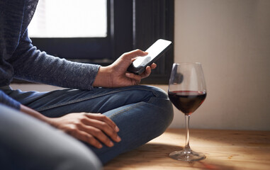 Dinners ready, are you on your way. Cropped shot of a woman sending a text message with a glass of...