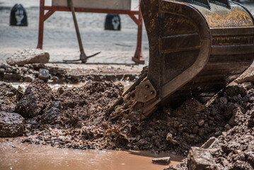 bulldozer shovel lifting debris strewn over the street