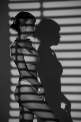 Half body Asian Woman 20s wear Bikini stay in shade of shadow from chick window curtain