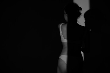 Half body Asian Woman 20s wear Bikini stay in shade of shadow from sunset window curtain