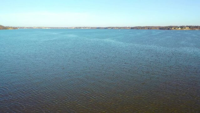 Calm Blue Waters Of Table Rock Lake in Midwest Branson Missouri With Boat Driving in Background. aerial drone pullback