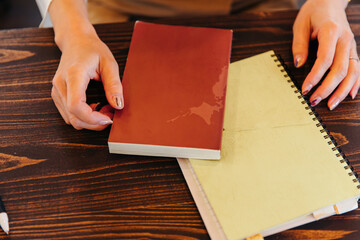 女性の手元にある単行本とリングノート　note