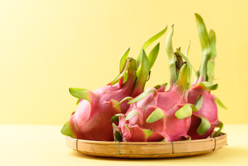 Fresh dragon fruit or pitaya in bamboo basket on yellow background, Tropical fruit