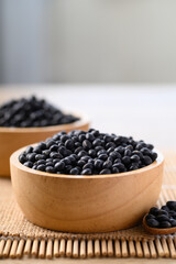Fototapeta na wymiar Black soybean seeds in wooden bowl, Food ingredients