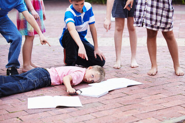 Youre such a nerd - Bullying. Shot of a young boy being picked on by a bunch of schoolkids.