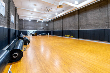 Wrestling room at school, gym, wooden floor, pads