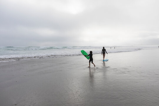 Girl (16-17) and boy (8-9)&nbsp;bodyboarding&nbsp;on Grotto Beach