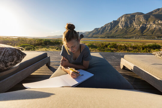 South Africa , Stanford, Girl (16-17) relaxing on deck, drawing in sketch pad