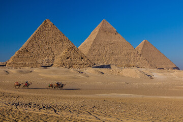 CAIRO, EGYPT - JANUARY 28, 2019: Camel riders in front of the Great pyramids of Giza, Egypt