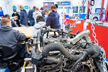 Students in a classroom, shop class, with engine