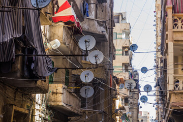 ALEXANDRIA, EGYPT - FEBRUARY 2, 2019: Narrow alley with satellite dishes in Alexandria, Egypt