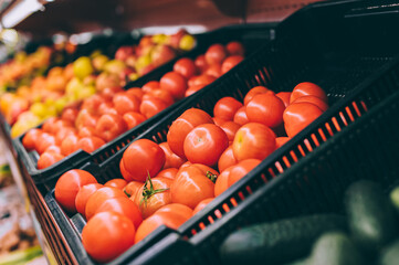 Close-up, tomatoes on the counters. Against the background of fruits in the supermarket.