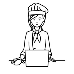 デスクで座ってPCを使っている調理師の女性