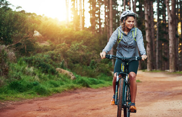 Shes an adventurous rider. Shot of a female mountain biker out for an early morning ride.