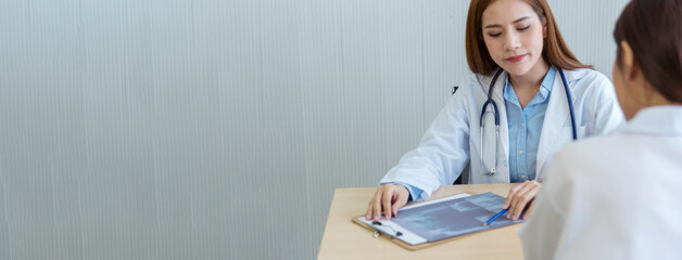 Banner Two asian women doctors discuss meeting office medical clinic. Young asian female doctor...