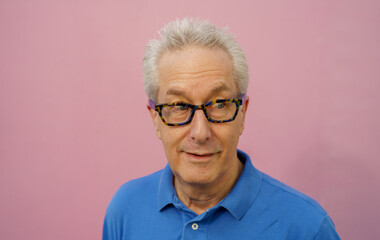 Handsome businessman in blue shirt on pink background