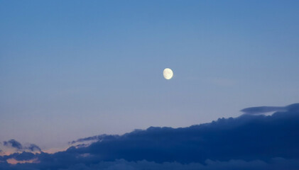 Mezza Luna del pomeriggio sopra le nuvole