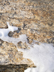 The surface of the rocky mountain is covered with ice and snow. Lake Baikal, Russia