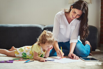 Mom is a great help with colouring. Cropped shot of a beautiful young mother helping her adorable...
