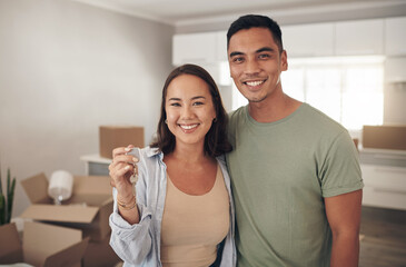 This is the key to a new beginning for us. Shot of a couple holding up the house key to their new...