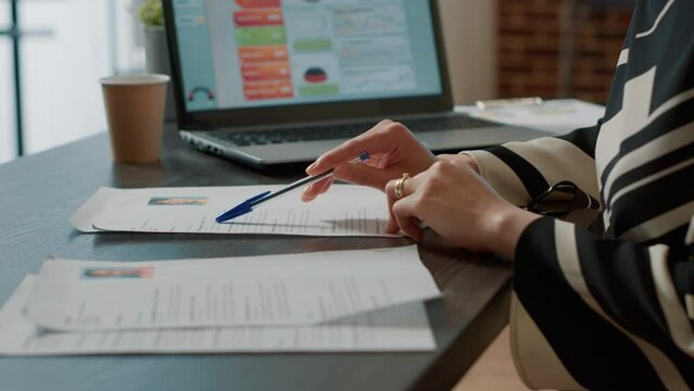 Office worker searching expertise information on resume for job application and vacancy hiring. Recruiter looking at cv documents, work experience forms for applicants career. Close up.