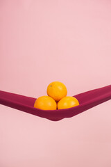 four oranges cut in half on a red cloth in front of a peach background as a symbol of the pelvic floor
