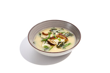 Japanese food - miso soup with tofu, wakame and shiitake mushroom. Vegetarian miso soup in ceramic bowl on isolated white background.