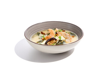 Japanese food - miso soup with tofu, wakame, prawn and shiitake mushroom. Miso soup with shrimp in ceramic bowl on isolated white background.