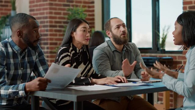 Displeased worker getting fired by multiethnic group of people, feeling sad about lost work and career. Female employee feeling angry about failure, losing job and being discharged.