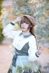 A beautiful woman in lolita dress in garden background Japanese street fashion portrait