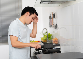 stressed man cooking and preparing food in the kitchen at home