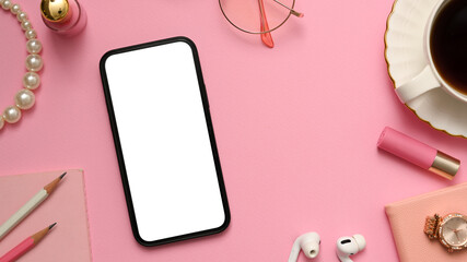 Feminine office desk with smartphone mockup on pink background.