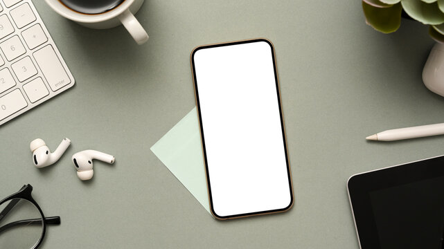 Smartphone mockup and office stuff on grey office desk.