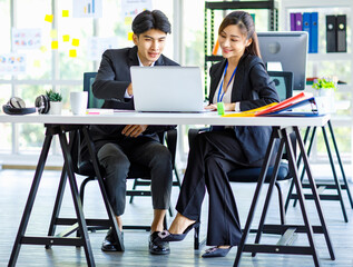 Asian young happy professional male businessman mentor and female businesswoman colleague in formal...