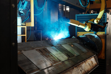 Process of arc welding produced by huge robotic industrial machine in large workshop of contemporary factory or plant