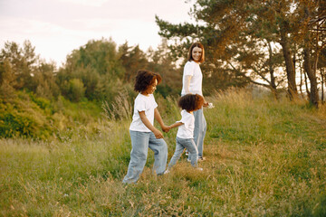 Caucasian mother and two her mixed race daughters walking in a park